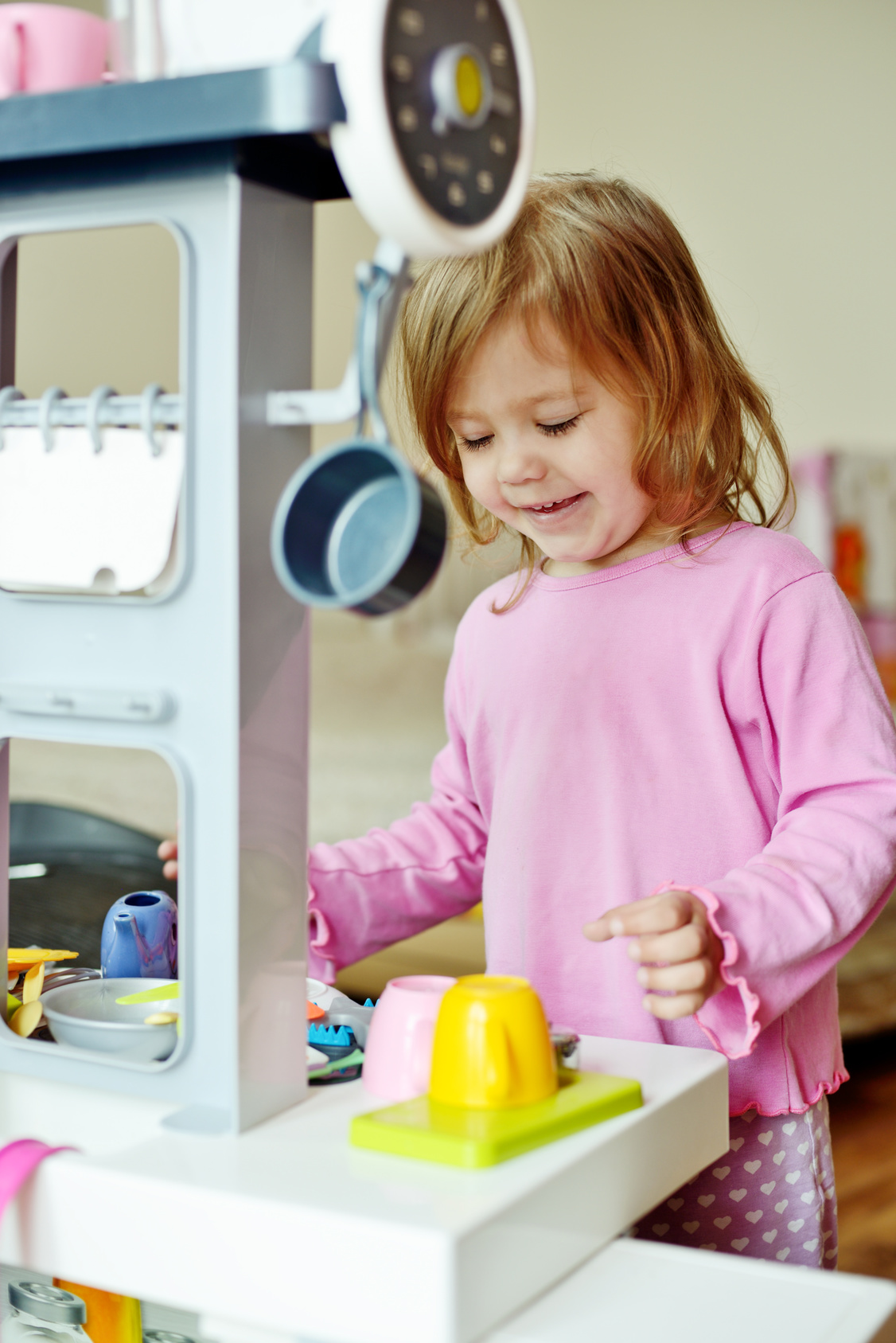toddler girl playing with kitchen at home